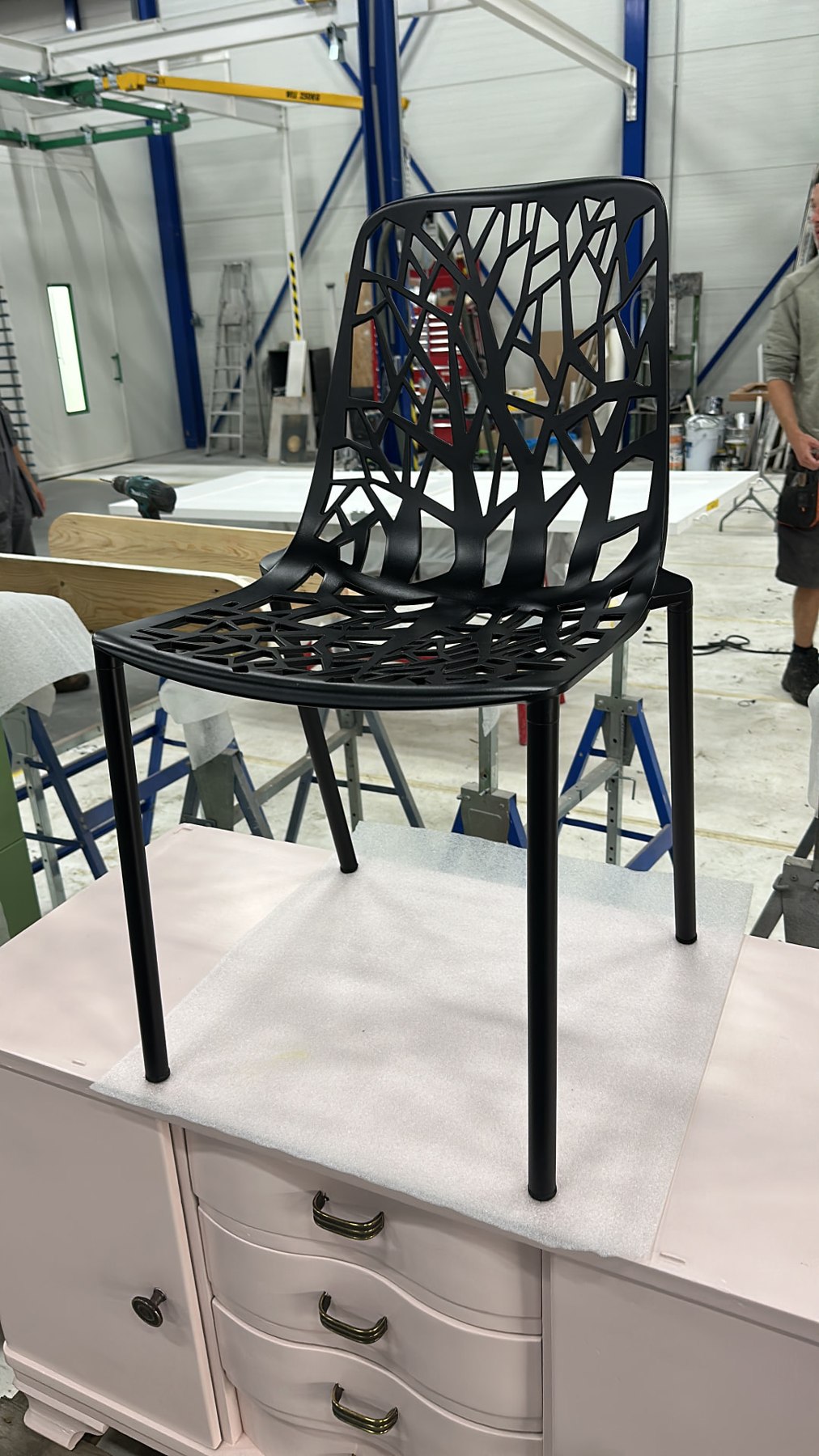Zwart afgewerkte designstoel met opengewerkte rugleuning