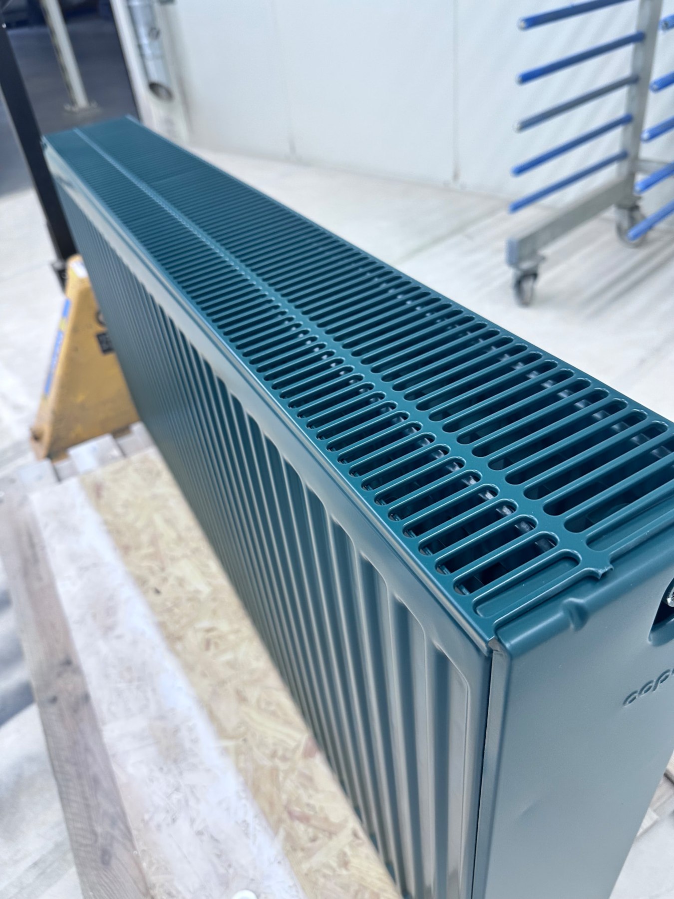 Blauwgroen gespoten radiator met strak afgewerkte bovenkant