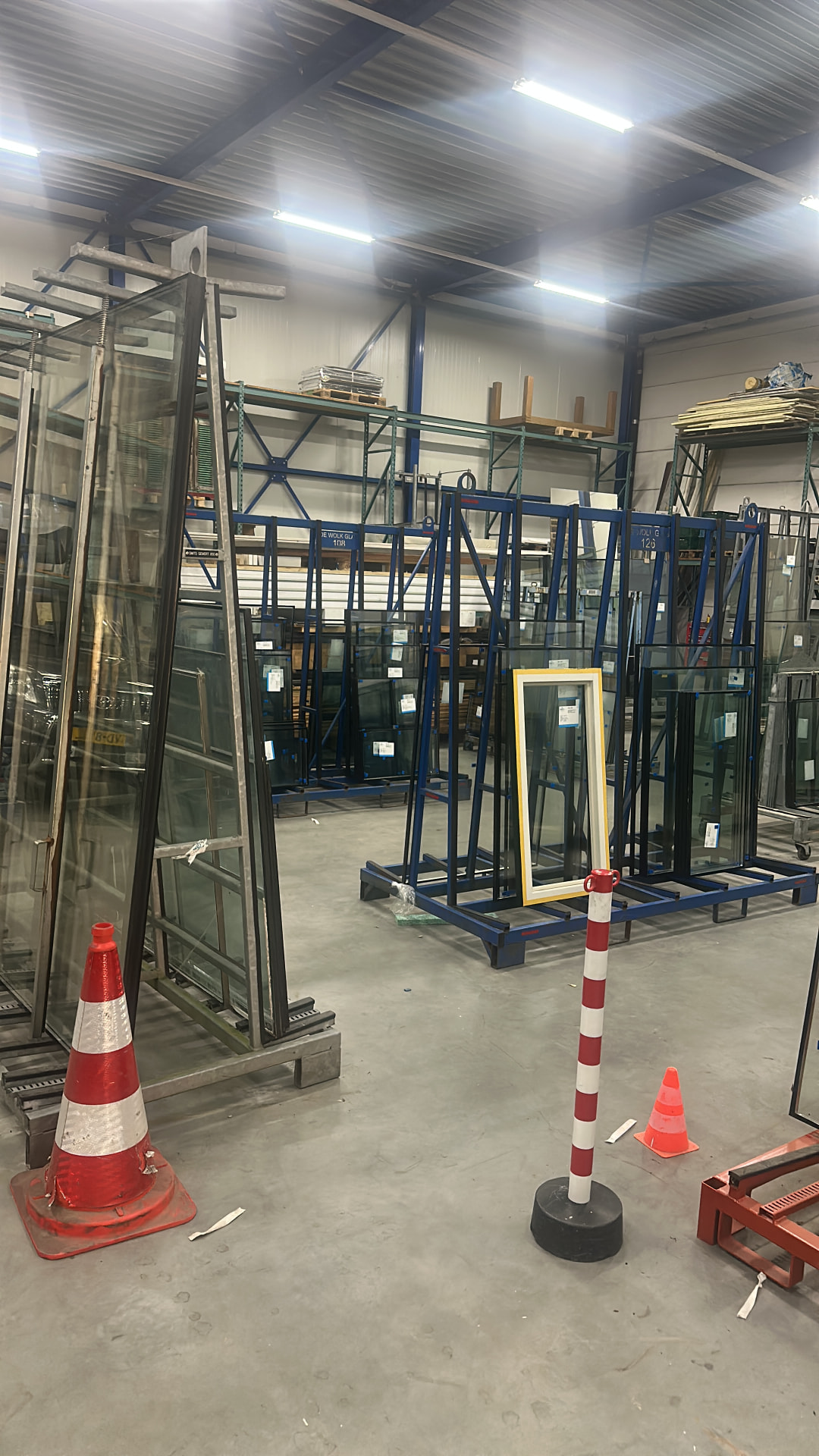 Overzicht van de loods met glasrekken en voorraad